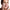 Woman applying a foamy facial cleanser to her face against a white background